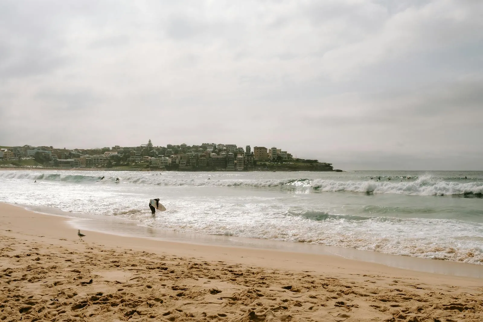 Surfers enjoy the waves at Bondi Beach, Sydney, showcasing a vibrant seaside scene.