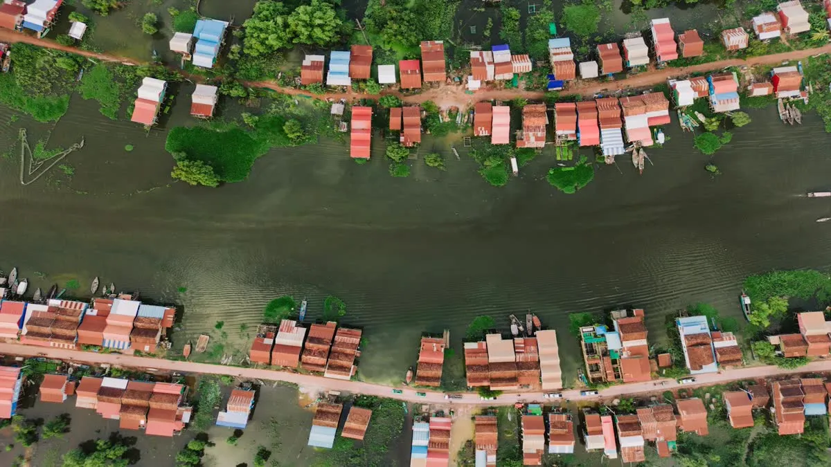 Aerial view of Kampong Khleang floating village and its stilt houses on a vibrant waterway.