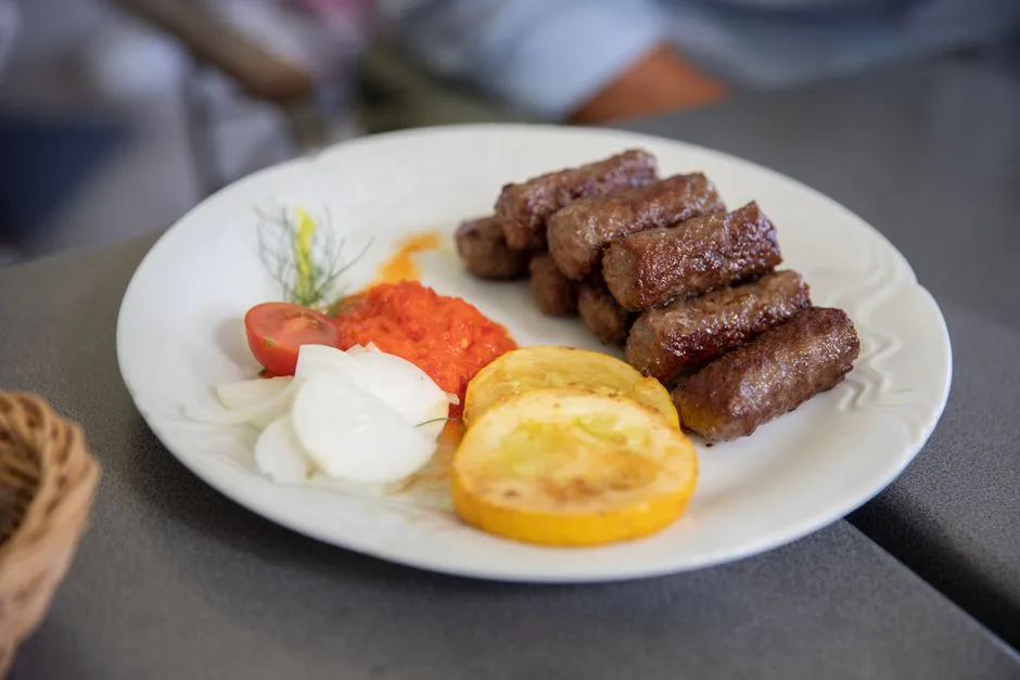 Plate of cevapi sausages with onions and flatbread