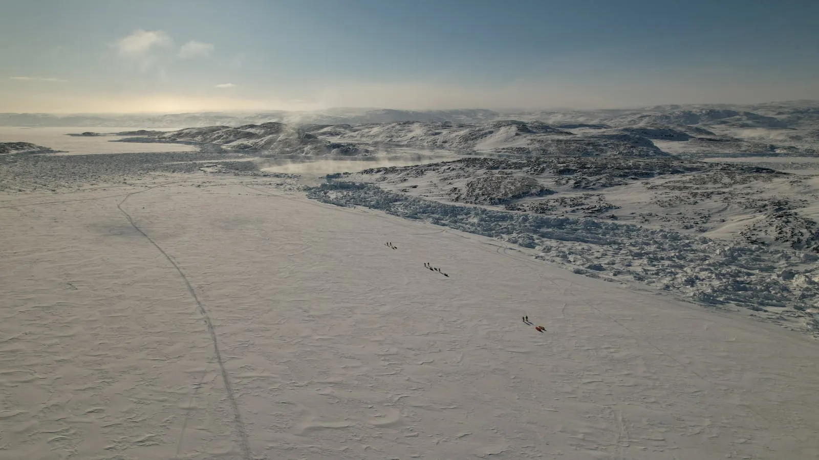 Hiker on an Arctic tundra trail in Greenland with mountains in the distance