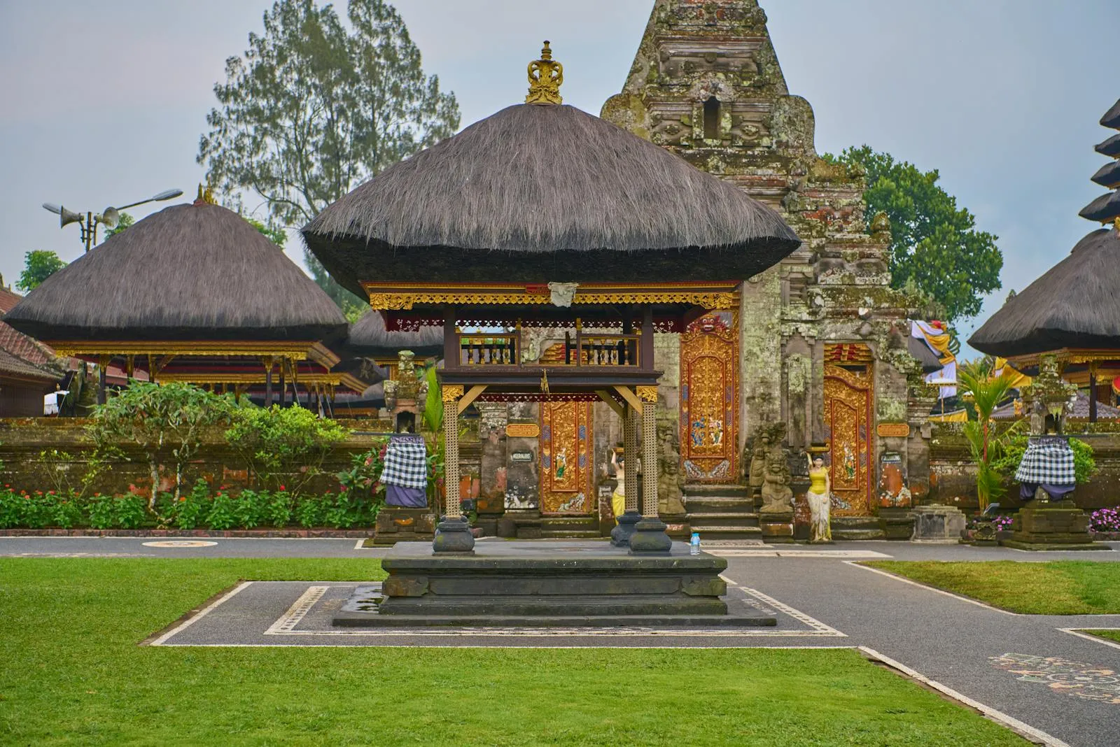 A stunning Balinese temple featuring traditional thatched roofs and intricate carvings.