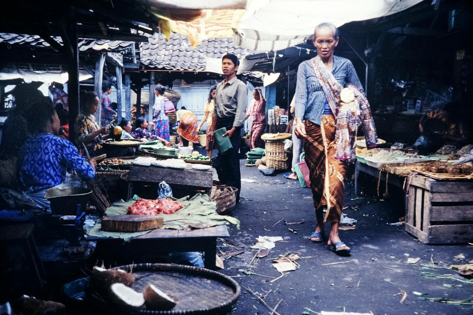 A bustling traditional market in Indonesia with vendors and shoppers engaging in daily trade.