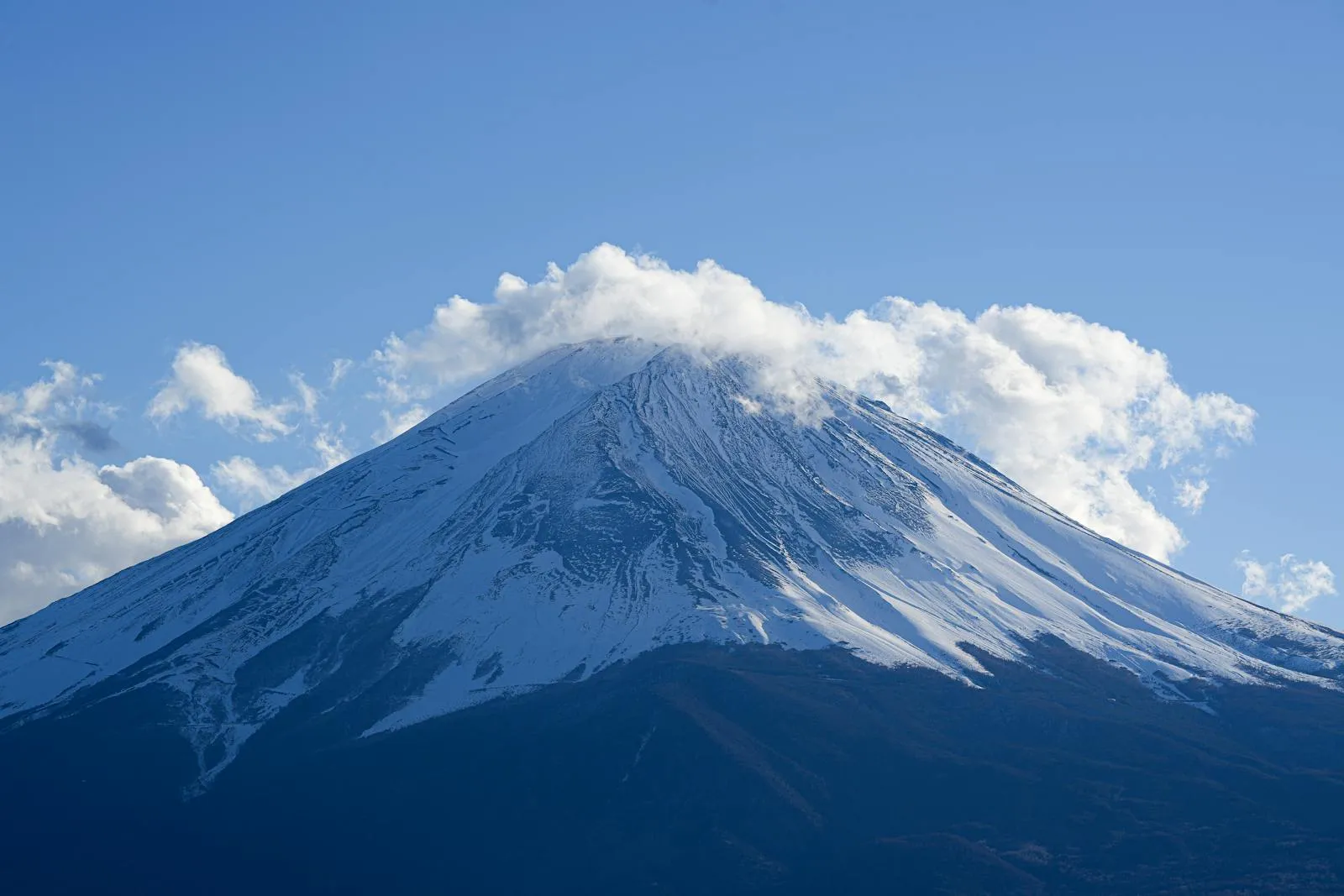 Serene view of snow-capped Mount Fuji under clear blue skies, perfect for nature lovers.