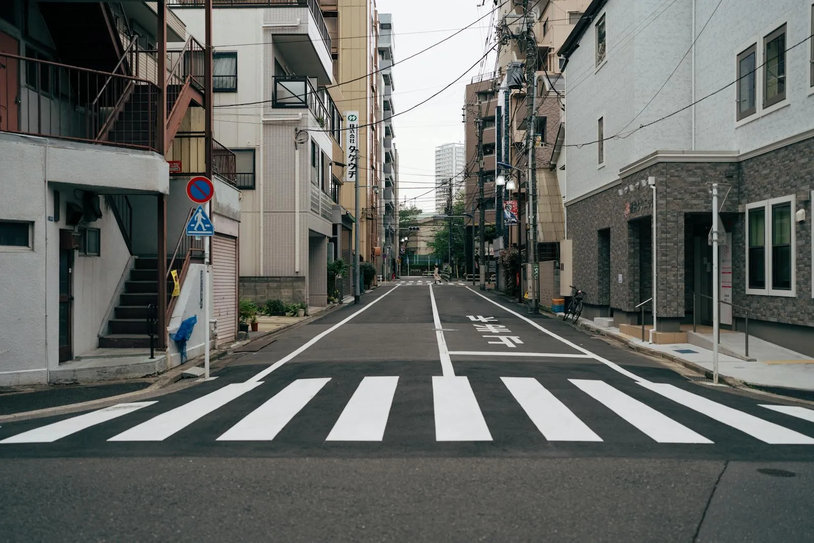 Tokyo city street with crosswalk and urban architecture, portraying Tokyo's urban atmosphere.