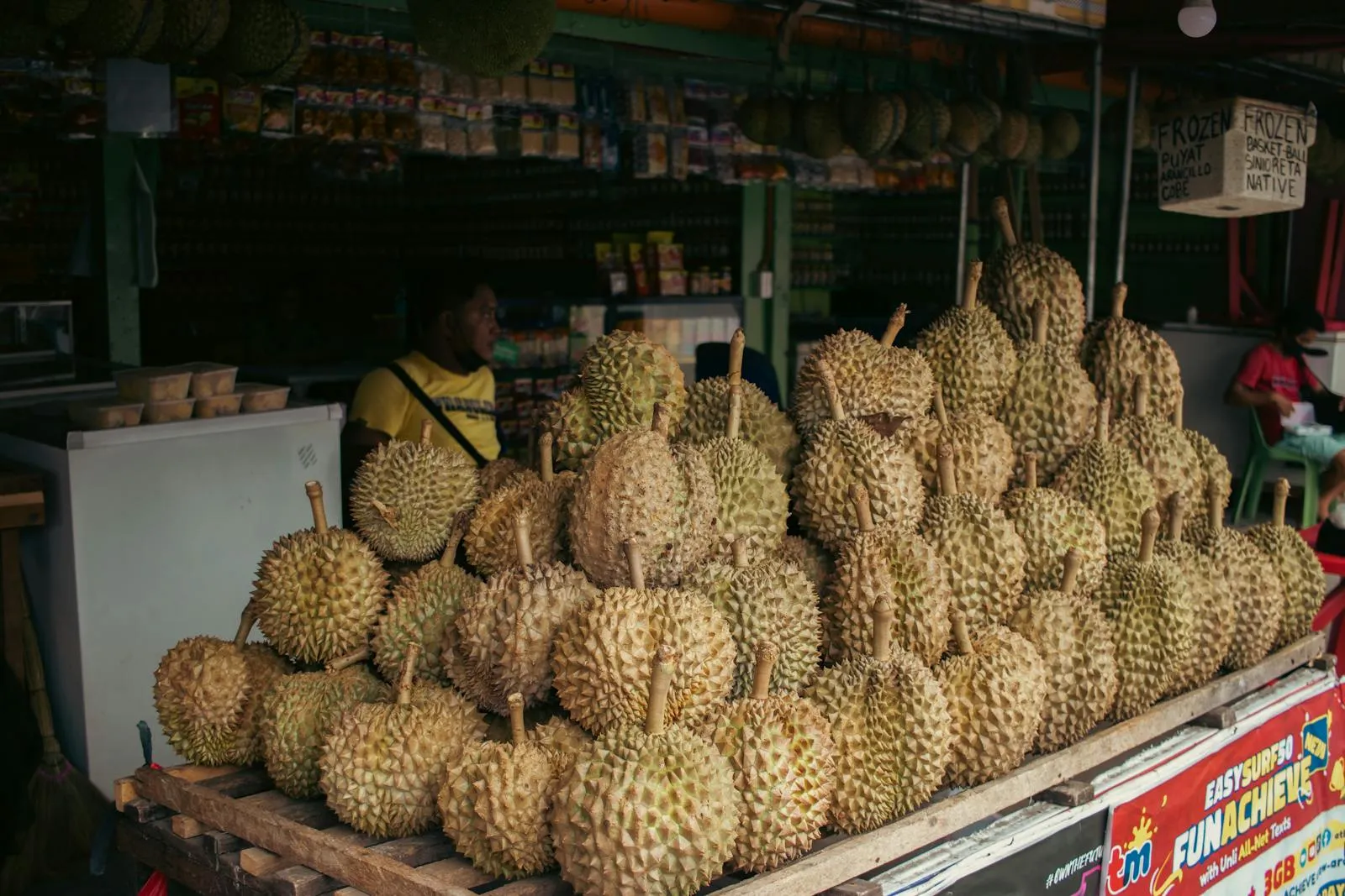 A vibrant market stall showcasing a pile of fresh durians in Davao City, Philippines.