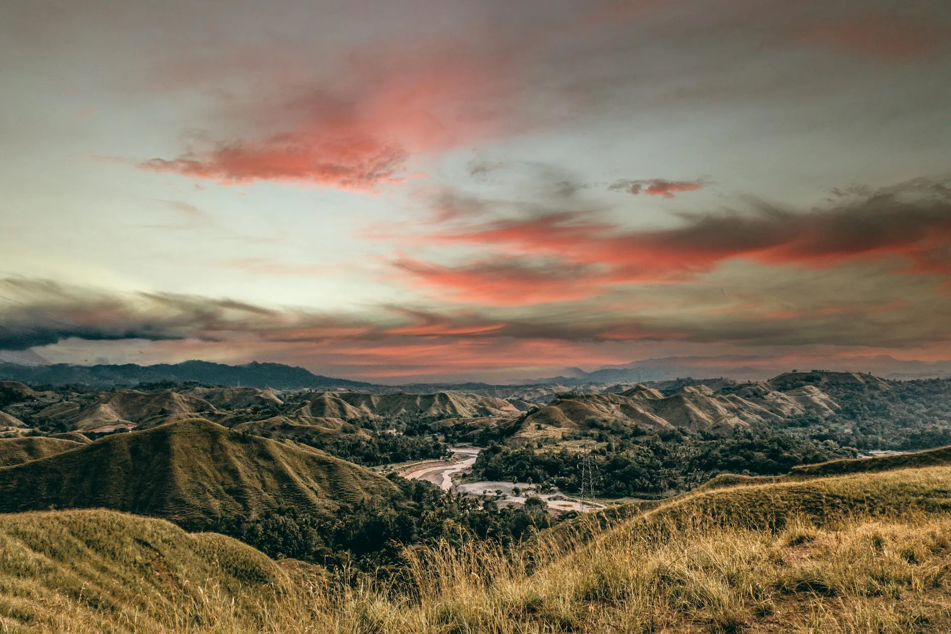 A stunning view of the rolling hills in the Philippines during sunset with a moody sky.