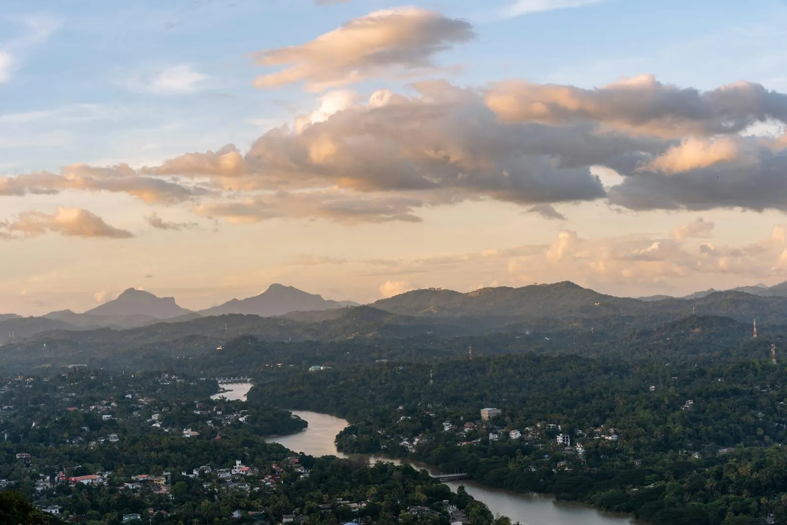 Beautiful landscape with river, hills, and a dramatic sky at dusk in Sri Lanka.
