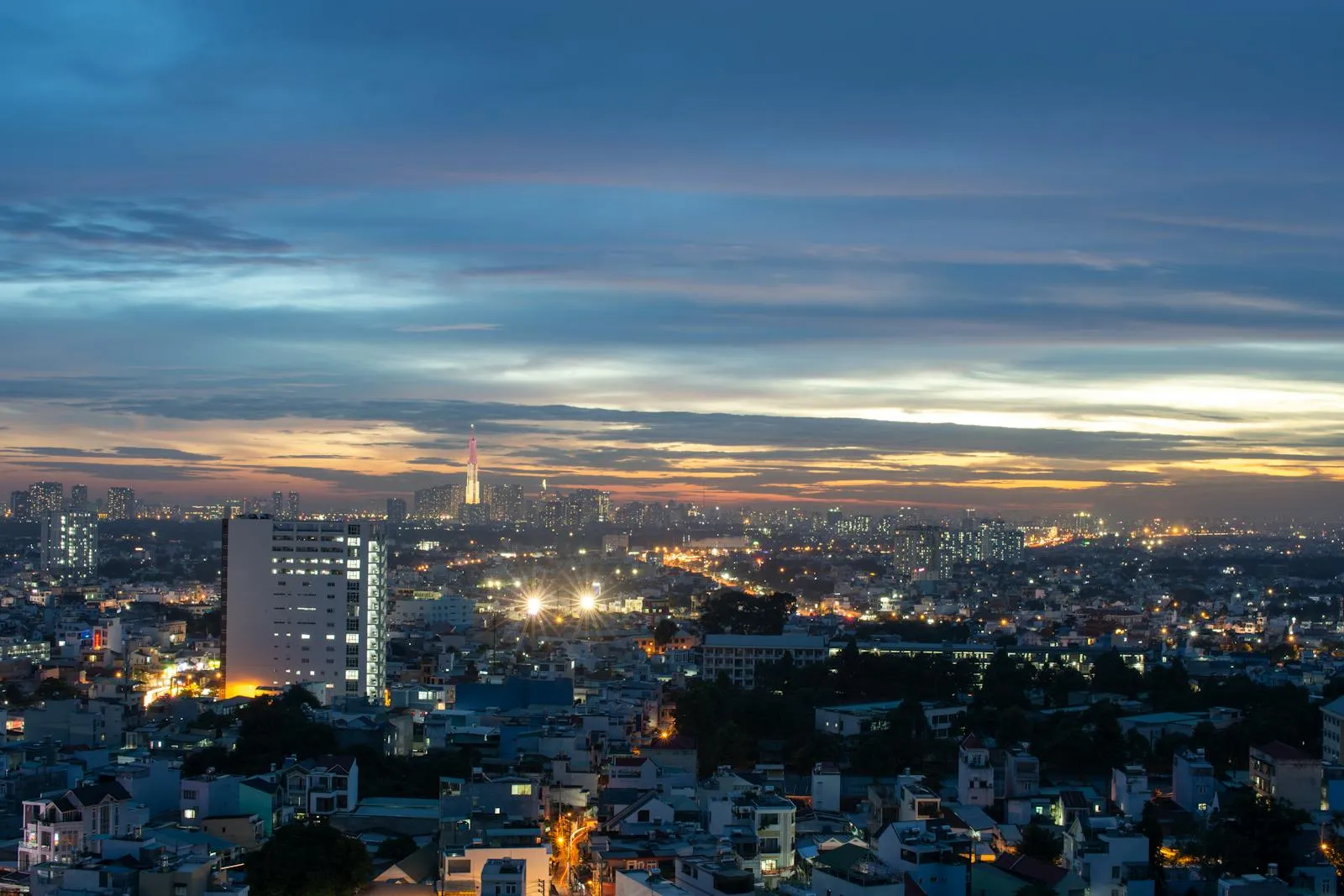 A stunning view of Ho Chi Minh City's skyline with modern architecture illuminated at dusk.