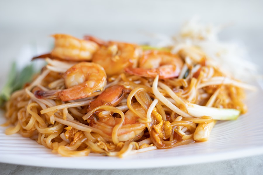 Thai street food stall with pad thai and wok flames
